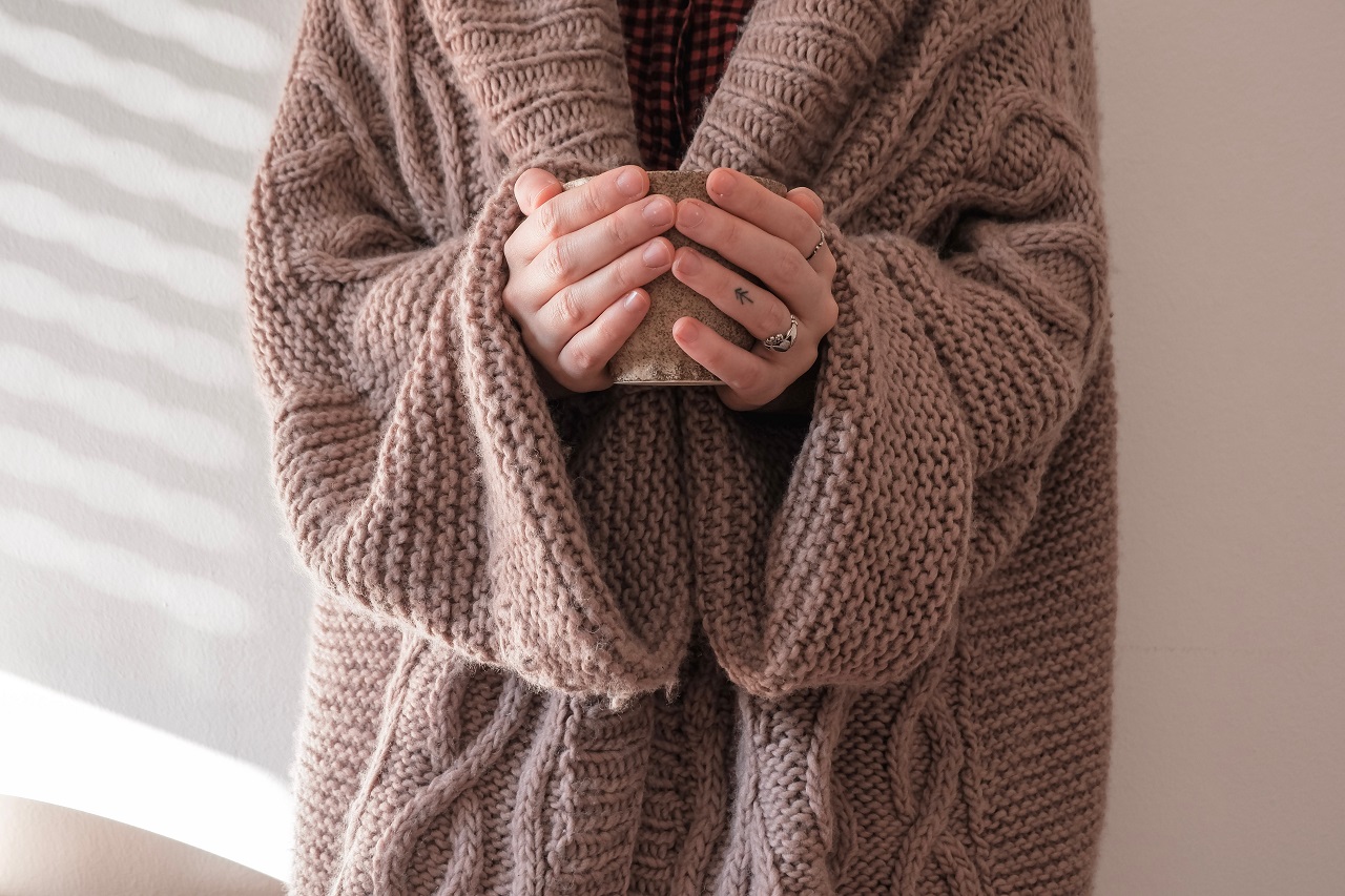 sweater holding mug