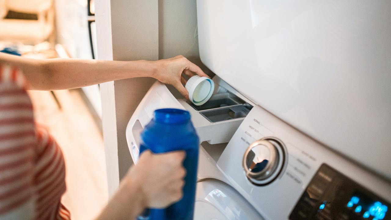 Women put Detergent into a washing machine