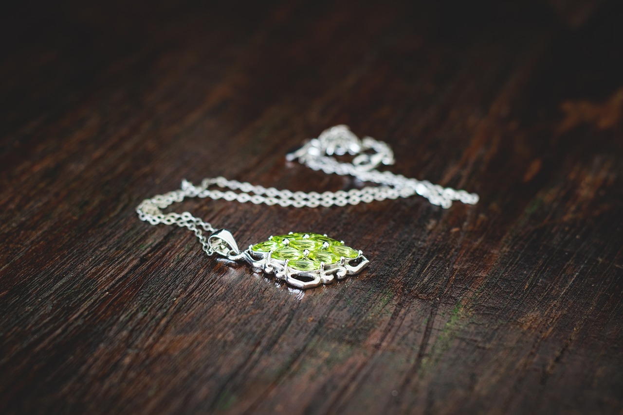 a necklace with green jewel on wood table