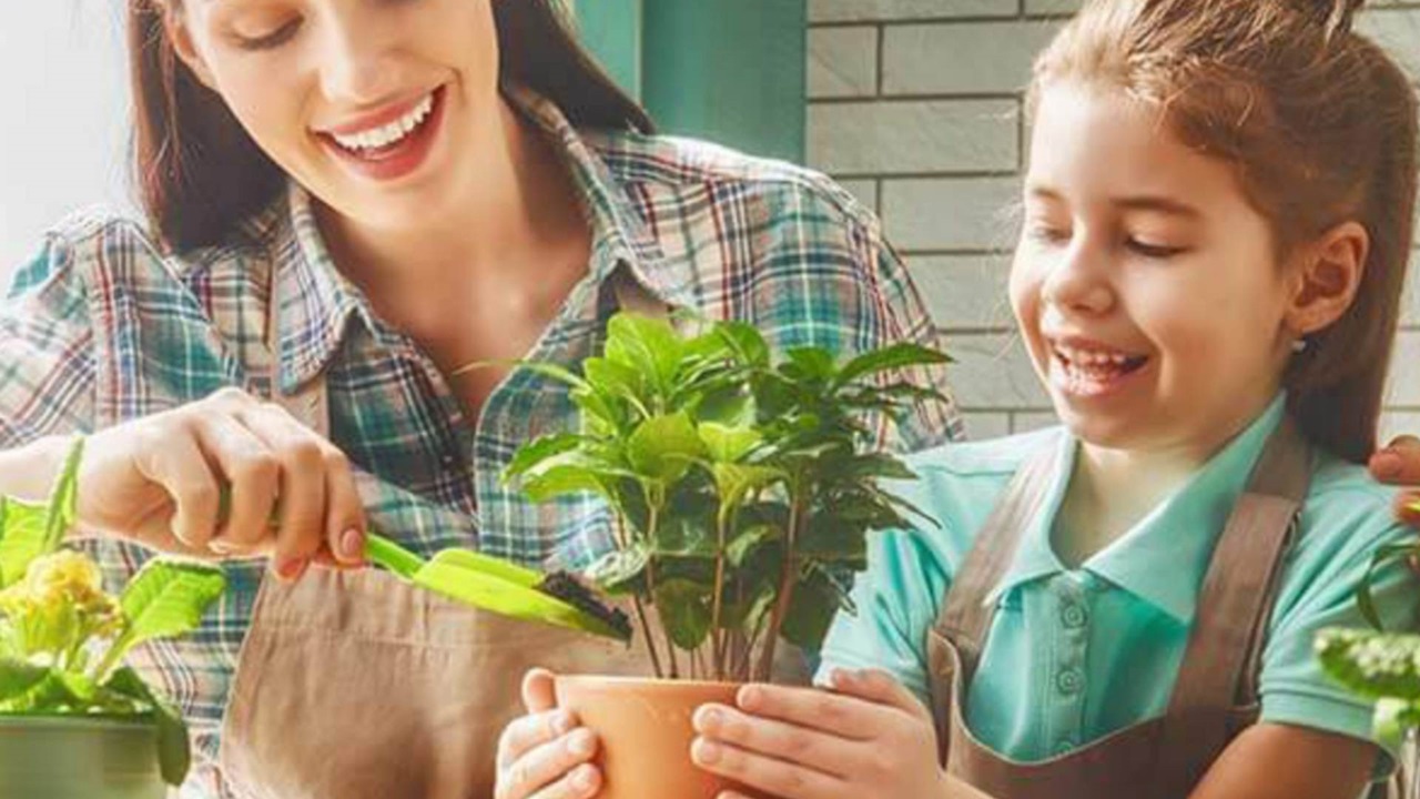 a mother and her young daughter are working together in the garden