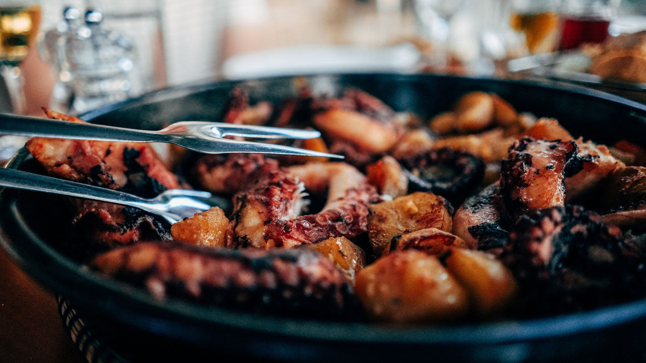 Simmering or braising the octopus in its own juices and added flavors