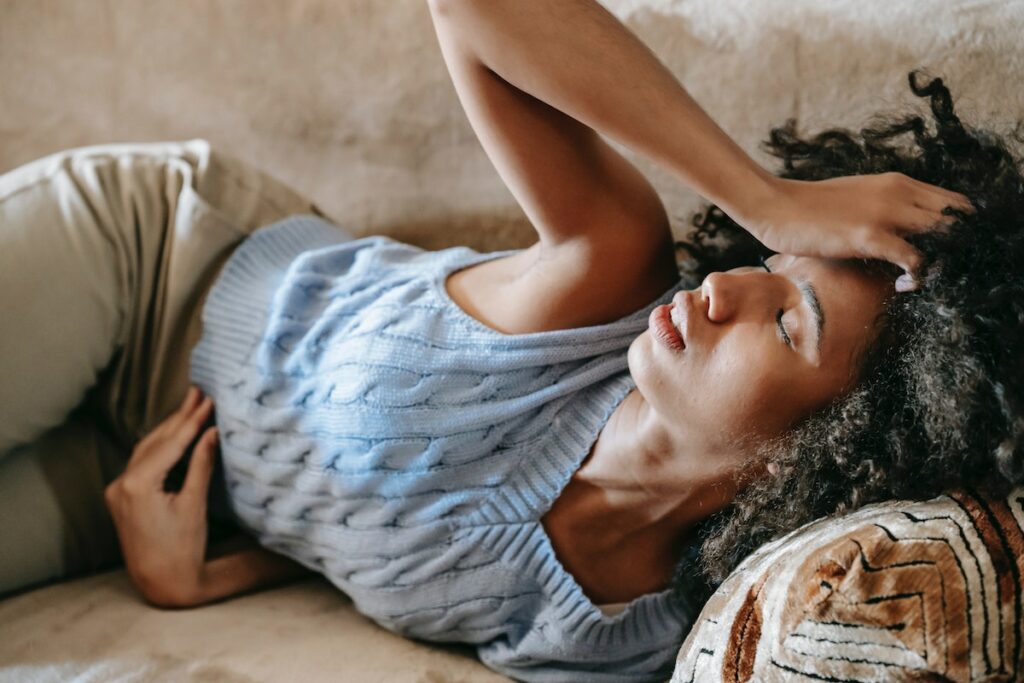a women is lying on the sofa and have abdominal pain.