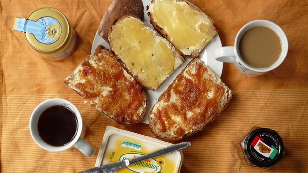 tea ,coffee and bread with melon jam on it is placed on the table