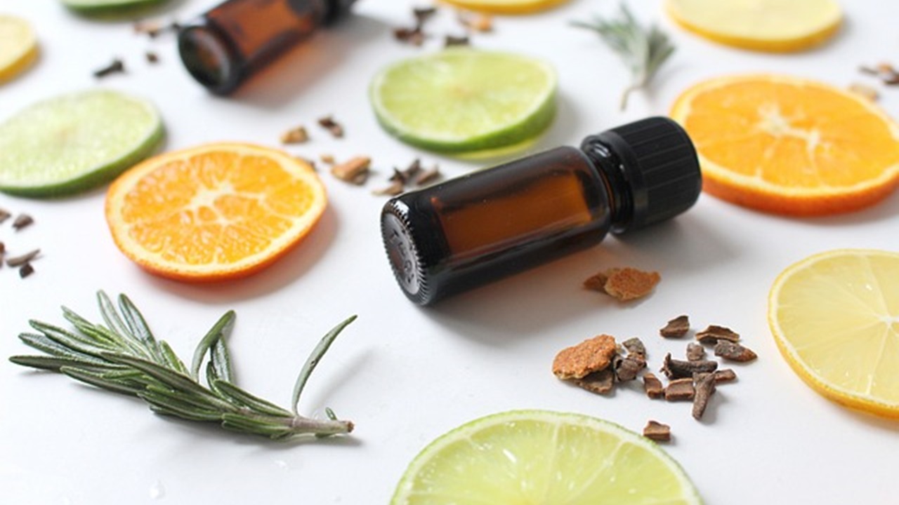 sliced lemons, cinnamon, and essential oil are placed on a table