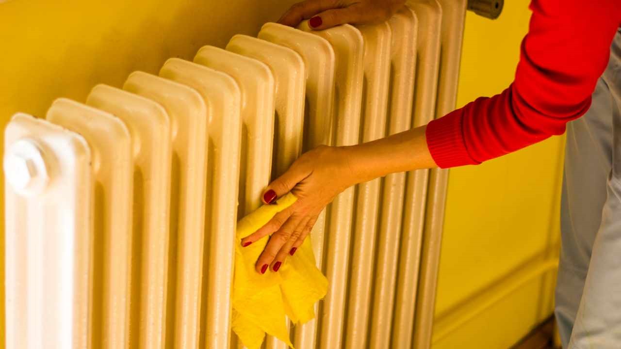 a women is cleaning the radiator with fibre cloth