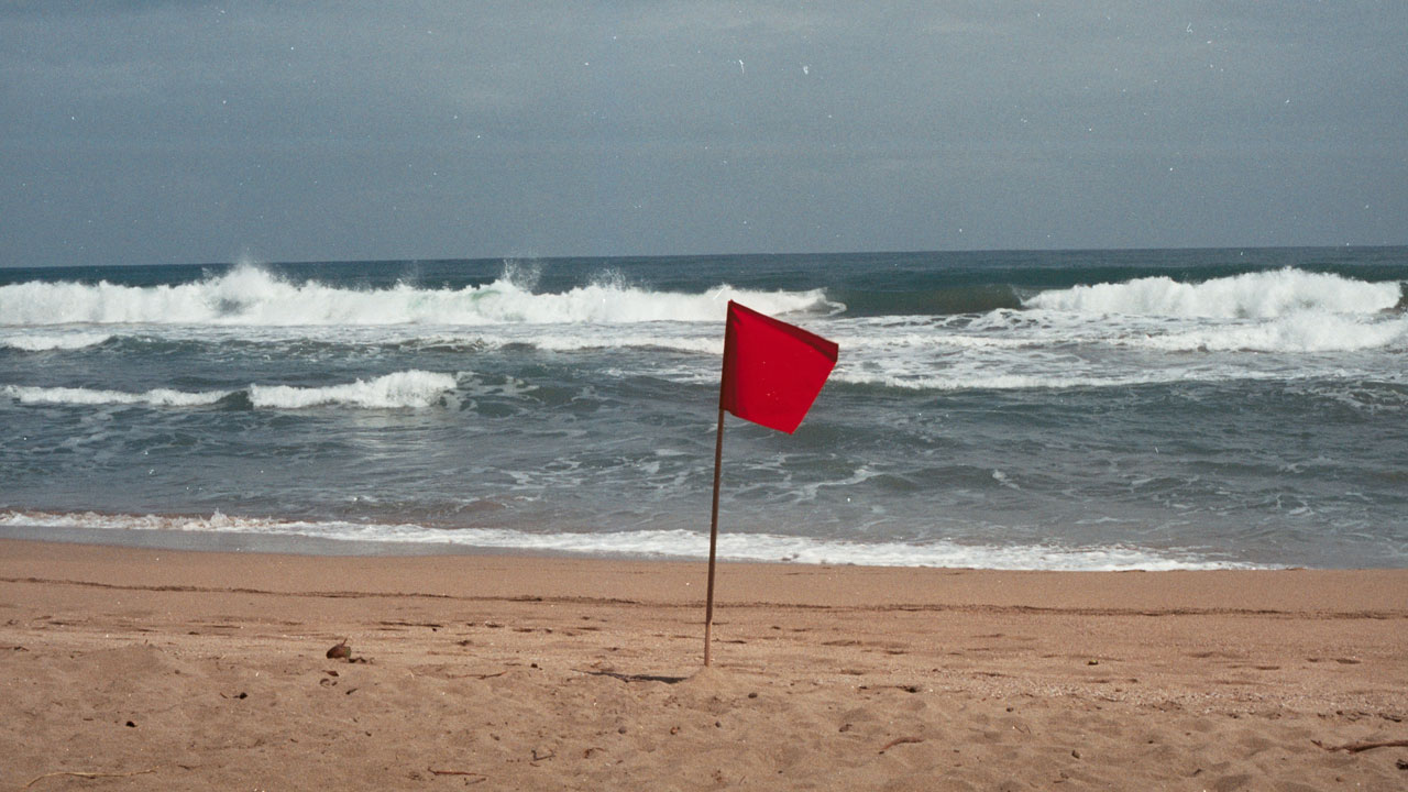 Red flag at the seaside means the sea is too rough.