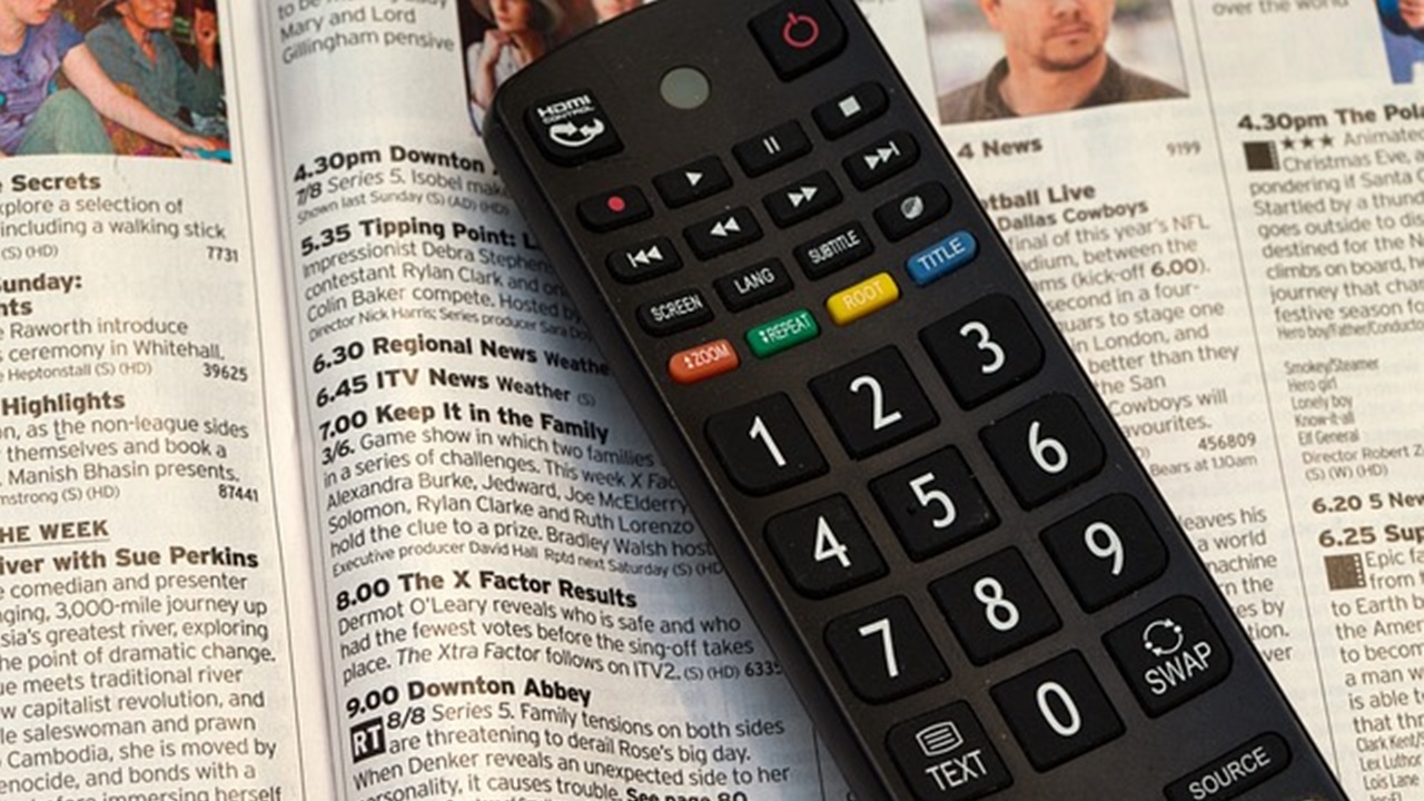 tv remote placed on the open book