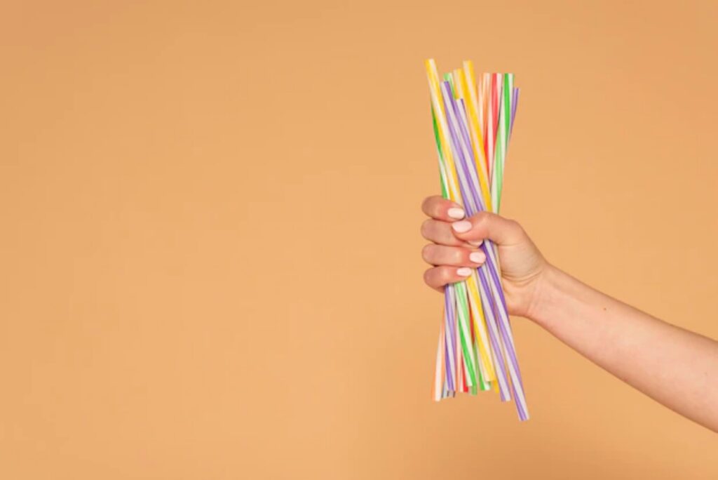 a person is holding some colorful straws in his hand