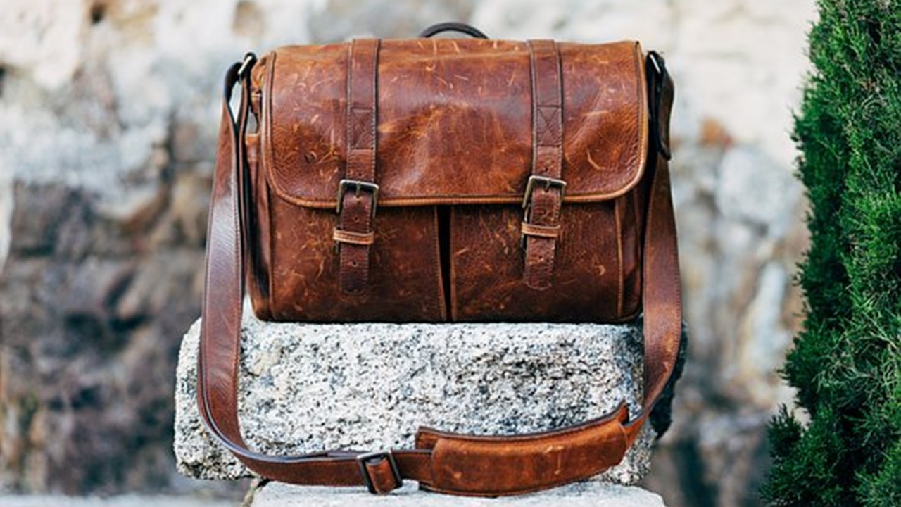 clean faux leather bag placed on a stone in the garden