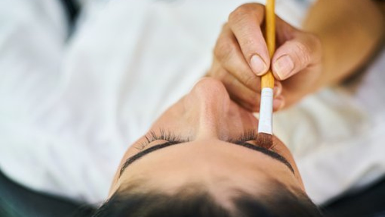 an expert is performing microblading on a girl