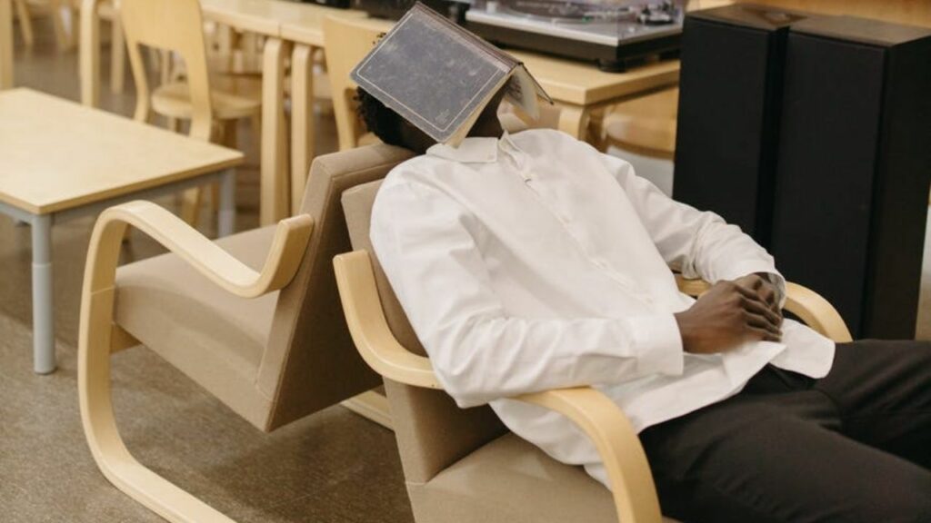 a man is feeling tired and lying in the chair