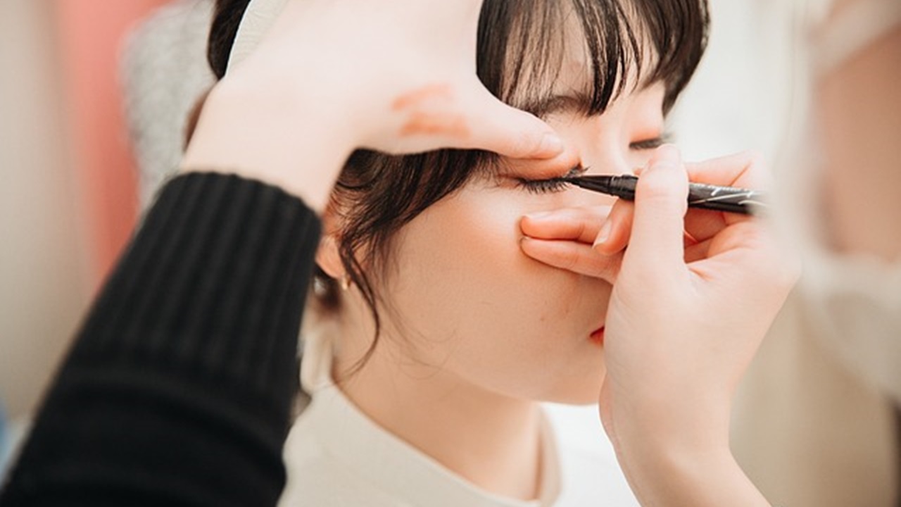 an expert is applying eyeliner to girl eyes
