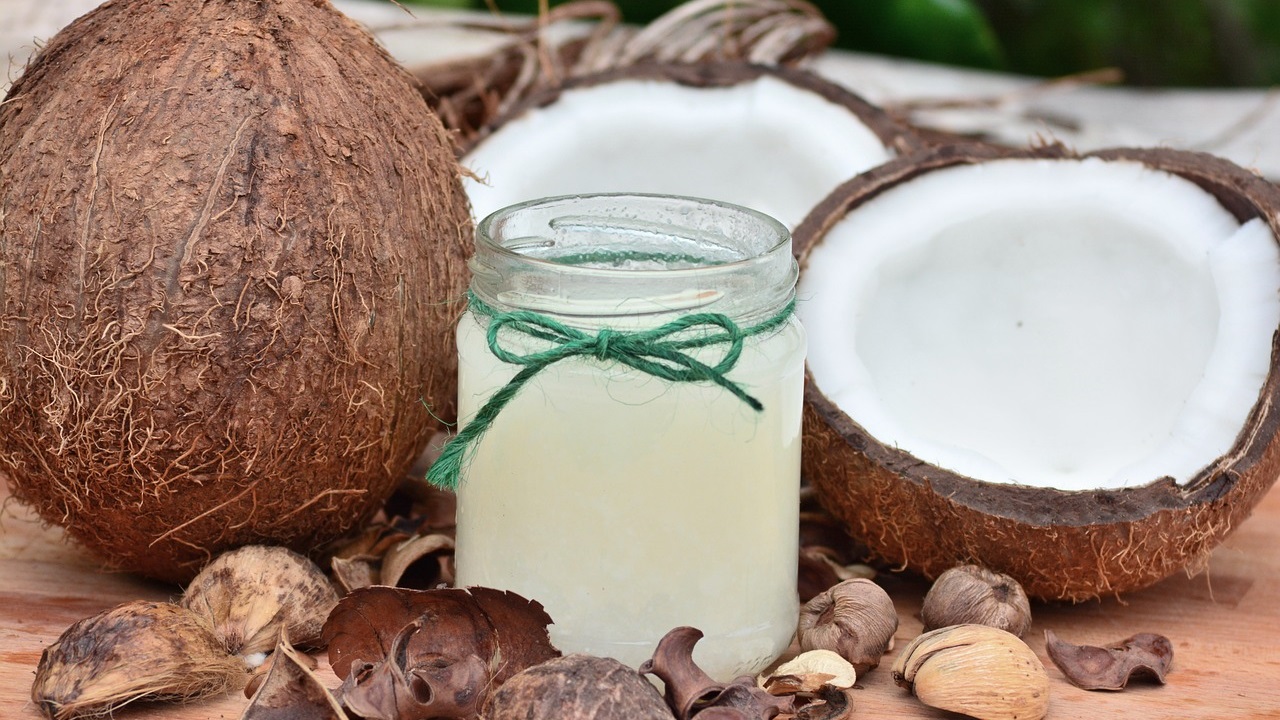 coconuts and coconut oil in a jar is placed on a table