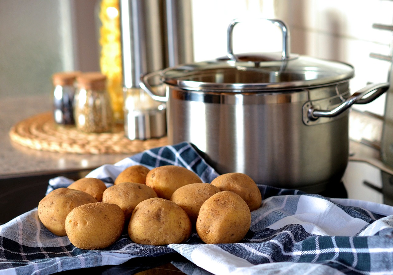 clean pot is placed on the slab with some potatoes in the kitchen