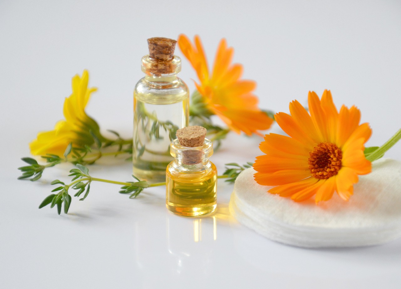 two small perfume bottles placed on the table with some flowers