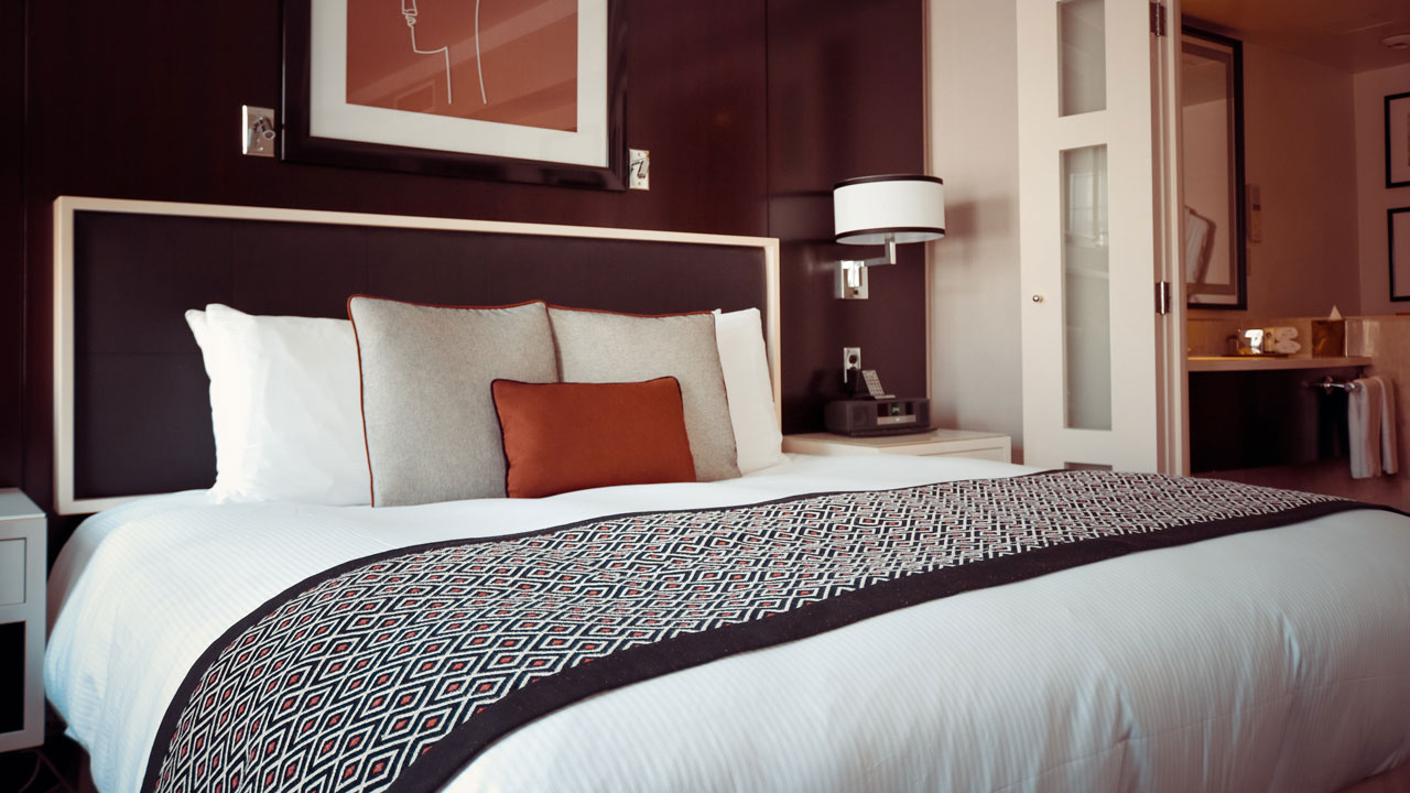 Bed runner is a decorative textile piece used for both aesthetic and practical purposes in hotel room design.