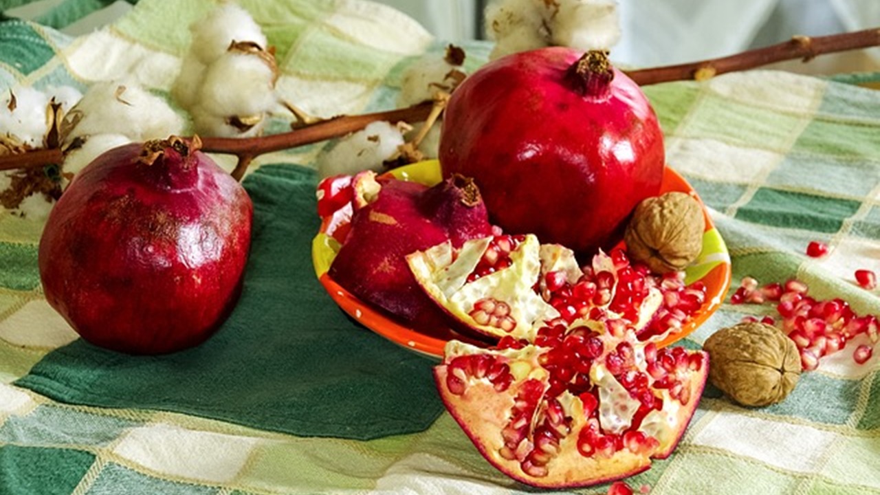 opening pomegranate in a bowl
