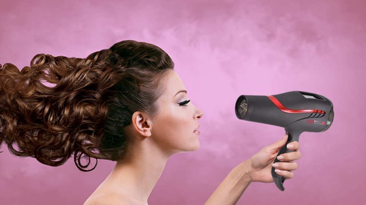 a girl is drying her hair with a hair dryer