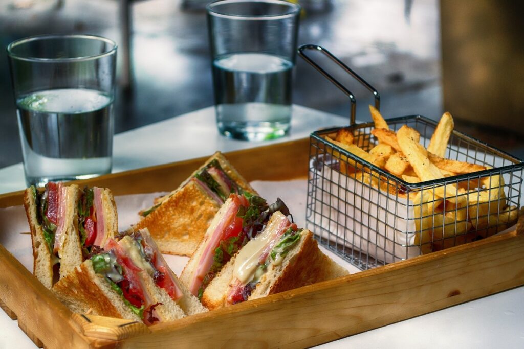 fried chips and sandwiches are served in a tray