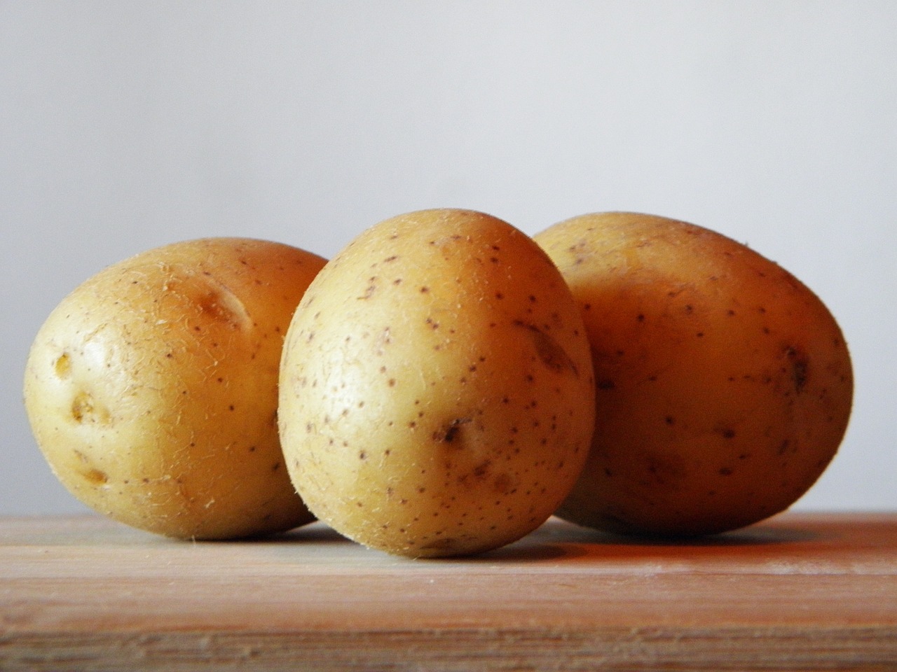 3 fresh potatoes are placed on the table