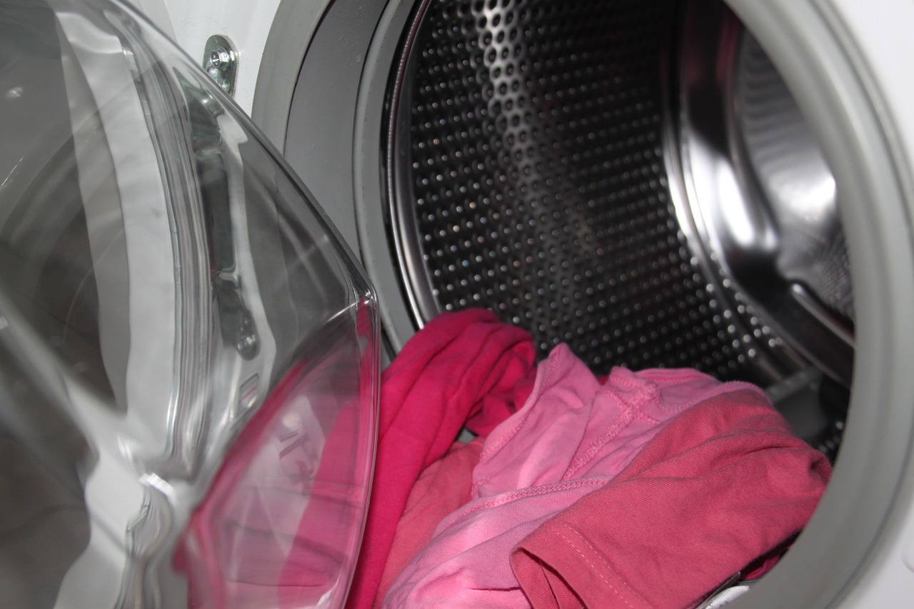 putting dirty clothes in the washing machine