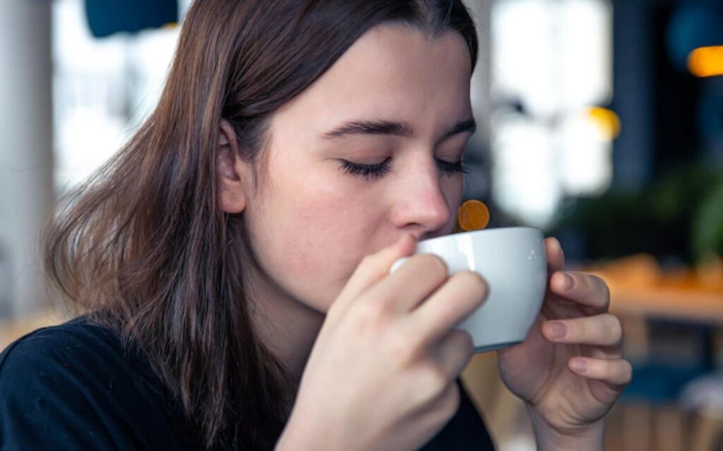 a girl is sipping coffee