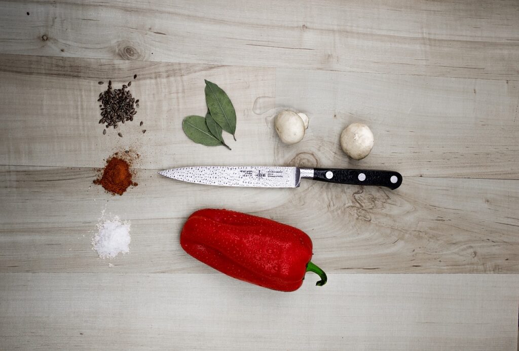 a knife and some vegetables are placed on a wooden table