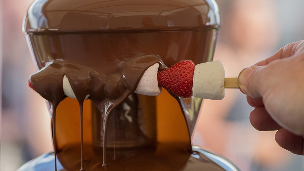 dipping strawberry in the chocolate fondue