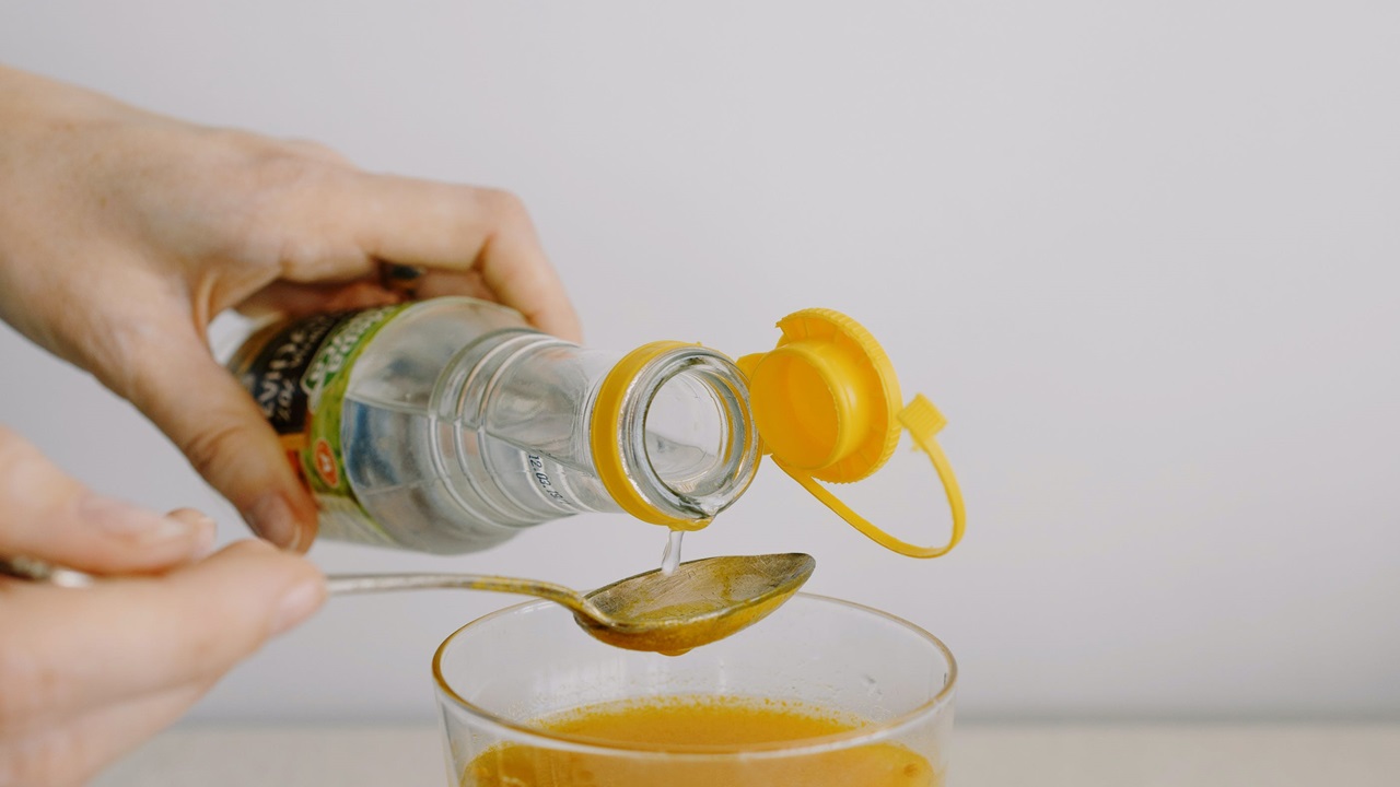 pouring 1 tablespoon of vinegar in the solution