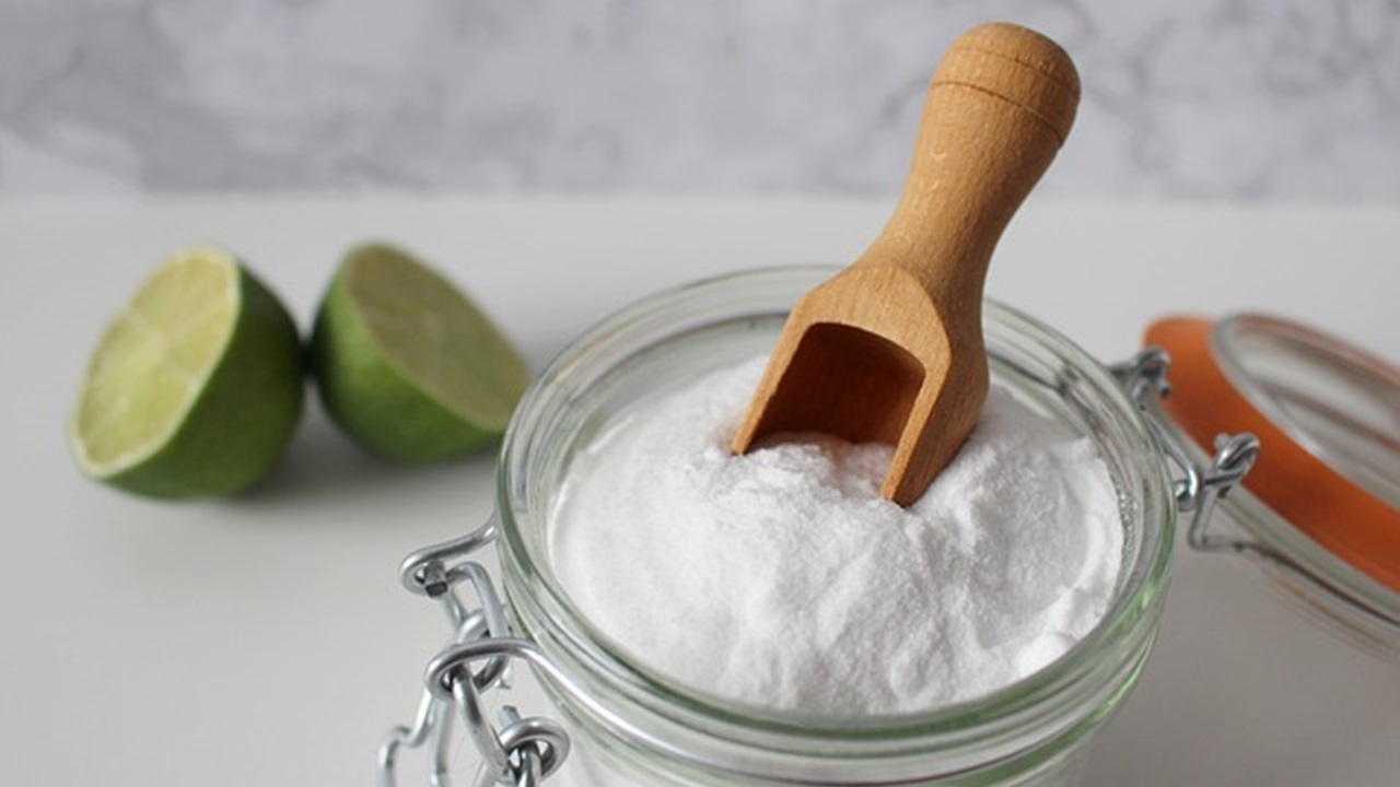 baking soda in the jar and a sliced lemon are placed on the table