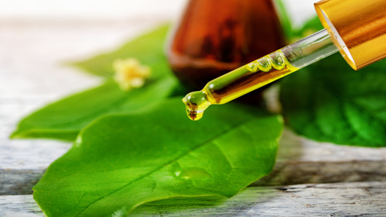 a person is pouring some tea tree oil drops on the  bay leaf