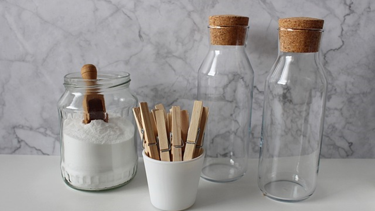 baking soda in the jar and 2 empty bottles are placed on the table