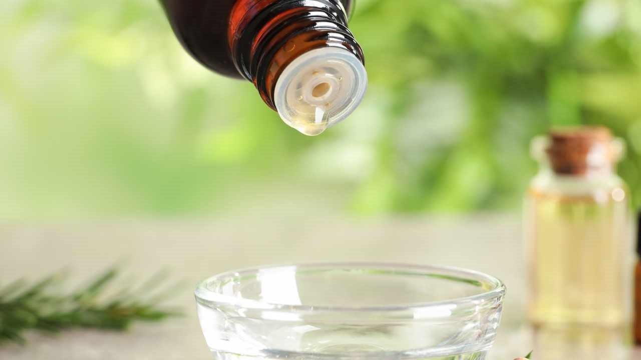 pouring drops of tea tree oil in a bowl