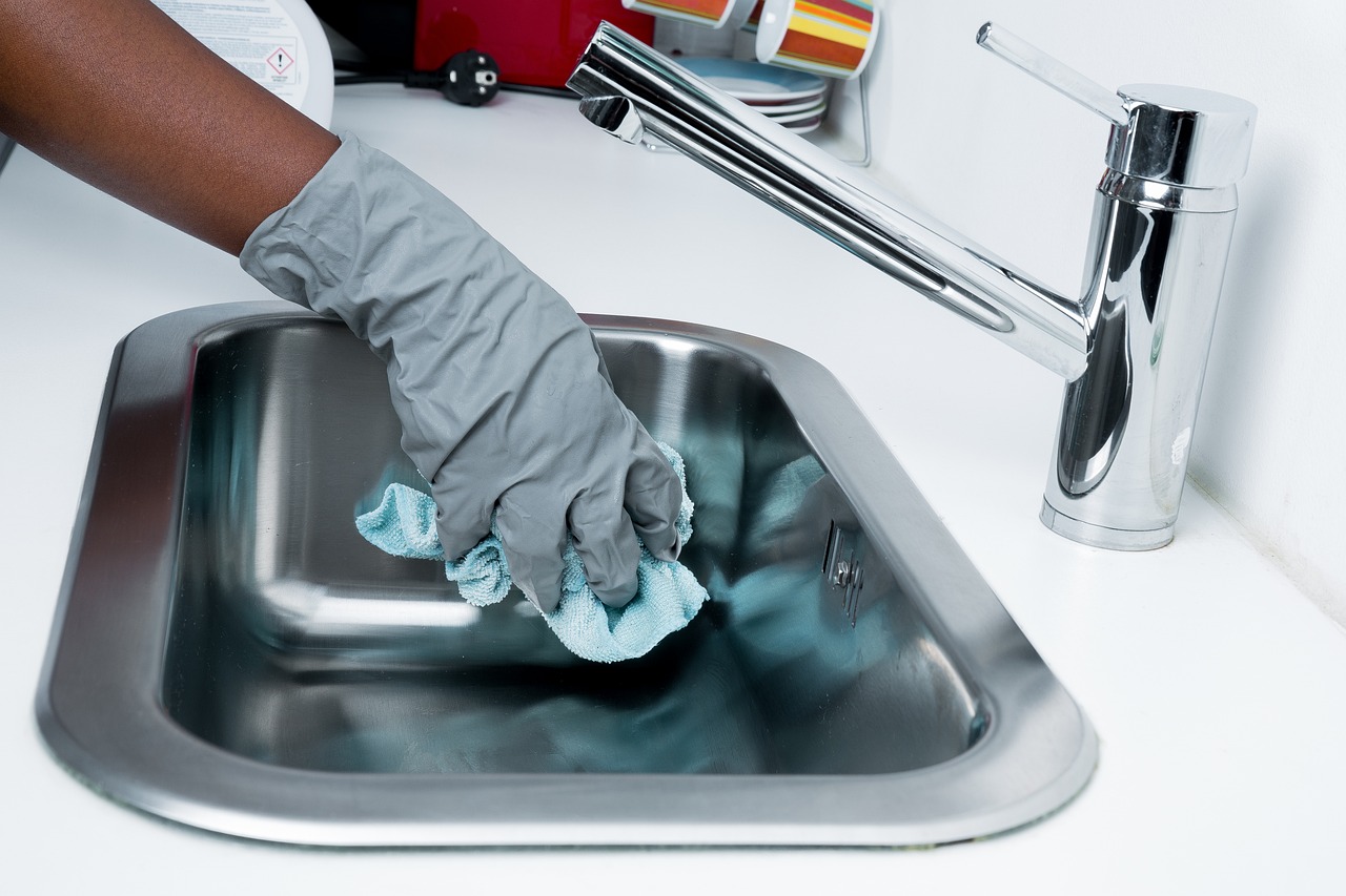 a person is cleaning the basin of the kitchen