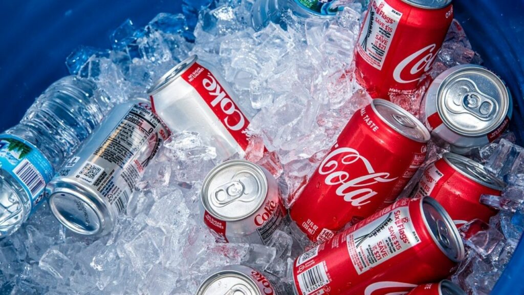 coca-cola cans are placed in a bucket with ice