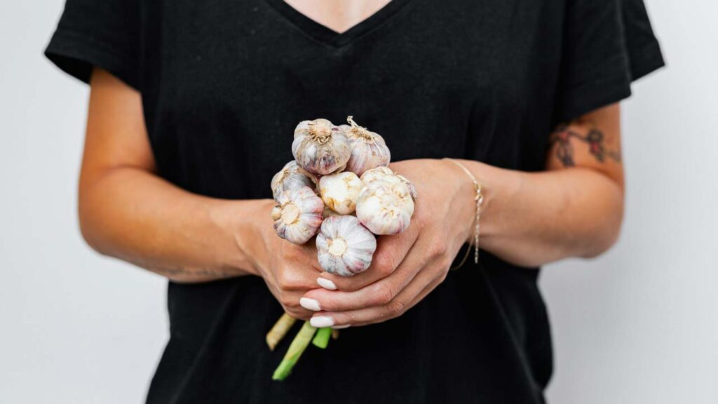 person is holding a chain of garlics